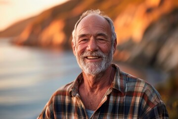 Wall Mural - Portrait of a grinning man in his 60s wearing a comfy flannel shirt isolated on serene seaside background