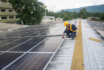 Wall Mural - A solar panel installation company employee assembles a photovoltaic system on the roof.