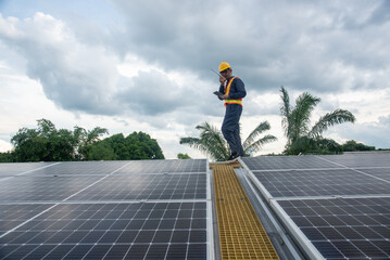 Wall Mural - a solar panel installation company employee assembles a photovoltaic system on the roof.