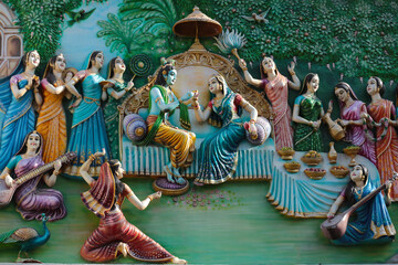 Wall Mural - Divine couple Radha and Krishna surrounded by gopis. Bas-relief on the wall of a Hindu temple in India.