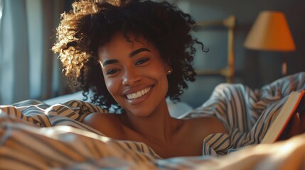 Wall Mural - A smiling woman in bed reading a book.