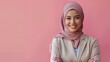 © PeopleWorker - Smiling Hijab Businesswoman with Tailored Suite standing on pink plain background