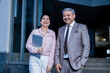© GAJENDRRA BHATI  - Indian senior businessman with his female colleague standing in office building smiling. corporate, entrepreneur and workplace concept.