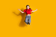 © deagreez - Full length portrait of cute little girl jump meditate wear t-shirt isolated on yellow color background