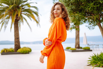 Wall Mural - Beautiful woman in summer dress walking along the street street city. Tropical climate. Concept of lifestyle, vacation, fashion, travel.