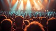 A crowd of people at a concert, watching a band perform.