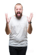 © Krakenimages.com - Young caucasian hipster man wearing casual t-shirt over isolated background celebrating mad and crazy for success with arms raised and closed eyes screaming excited. Winner concept