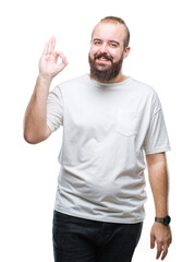 Wall Mural - Young caucasian hipster man wearing casual t-shirt over isolated background smiling positive doing ok sign with hand and fingers. Successful expression.