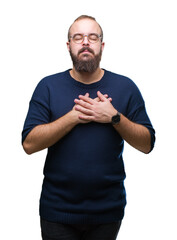 Wall Mural - Young caucasian hipster man wearing sunglasses over isolated background smiling with hands on chest with closed eyes and grateful gesture on face. Health concept.