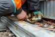© denklim - Plumber Working on Outdoor Water Line in Daylight