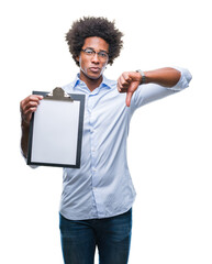 Canvas Print - Afro american man holding clipboard over isolated background with angry face, negative sign showing dislike with thumbs down, rejection concept