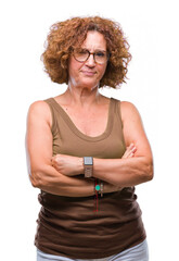 Wall Mural - Middle age hispanic woman wearing glasses over isolated background skeptic and nervous, disapproving expression on face with crossed arms. Negative person.