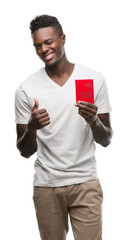 Sticker - Young african american man holding passport of Switzerland happy with big smile doing ok sign, thumb up with fingers, excellent sign