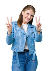 Wall Mural - Beautiful middle age mature woman wearing fashion leather jacket over isolated background smiling looking to the camera showing fingers doing victory sign. Number two.