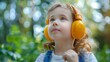 © antkevyv - Cute little girl listening to music with headphones in park, happiness lifestyle carefree joy
