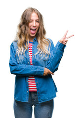 Sticker - Beautiful young blonde woman over isolated background smiling with happy face winking at the camera doing victory sign. Number two.