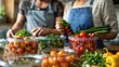 © LifeMedia - Two individuals work together to prepare fresh vegetables, including tomatoes and broccoli, in a kitchen setting, emphasizing teamwork and healthy eating in a modern culinary environment.