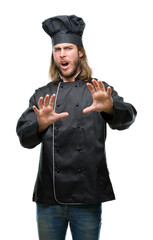 Wall Mural - Young handsome cook man with long hair over isolated background afraid and terrified with fear expression stop gesture with hands, shouting in shock. Panic concept.