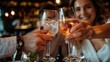 © LifeMedia - People clink their glasses in a festive environment, celebrating a dining party with colorful drinks and a background adorned with shimmering lights, capturing the essence of festivity.