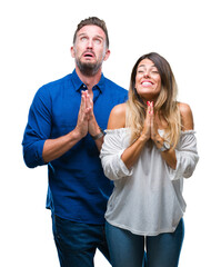 Sticker - Young couple in love over isolated background begging and praying with hands together with hope expression on face very emotional and worried. Asking for forgiveness. Religion concept.