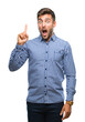 © Krakenimages.com - Young handsome man over isolated background pointing finger up with successful idea. Exited and happy. Number one.