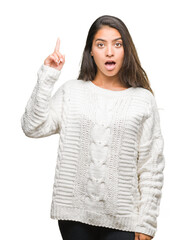 Sticker - Young beautiful arab woman wearing winter sweater over isolated background pointing finger up with successful idea. Exited and happy. Number one.