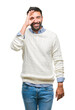 © Krakenimages.com - Adult hispanic man wearing winter sweater over isolated background doing ok gesture with hand smiling, eye looking through fingers with happy face.