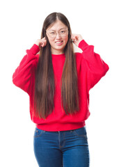 Sticker - Young Chinese woman over isolated background wearing glasses covering ears with fingers with annoyed expression for the noise of loud music. Deaf concept.