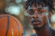 © Nena Photo - A young basketball player is seen with sweat on his face, focusing intensely on the game and holding a basketball, indicating dedication and effort on the outdoor court.