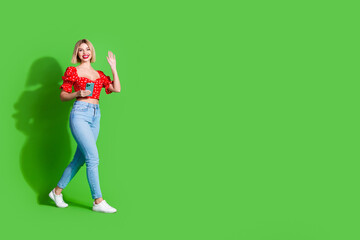 Wall Mural - Photo of adorable lovely girl wear red trendy clothes hold samsung go empty space isolated on green color background