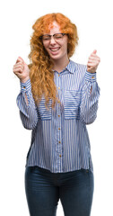 Sticker - Young redhead bussines woman excited for success with arms raised celebrating victory smiling. Winner concept.