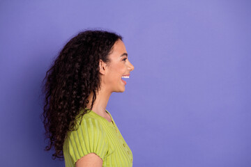 Wall Mural - Photo portrait of attractive teen woman profile laugh look empty space dressed stylish green clothes isolated on purple color background
