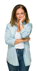 Canvas Print - Middle age adult woman wearing casual denim shirt over isolated background thinking looking tired and bored with depression problems with crossed arms.