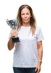 Wall Mural - middle age hispanic winner woman celebrating award holding trophy over isolated background with a co
