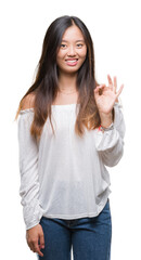 Wall Mural - Young asian woman over isolated background smiling positive doing ok sign with hand and fingers. Successful expression.