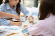 © Thitisak - Business woman Discuss and plan work on graph documents at the office