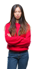 Canvas Print - Young asian woman wearing winter sweater over isolated background skeptic and nervous, disapproving expression on face with crossed arms. Negative person.