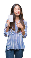 Canvas Print - Young asian woman holding notebook over isolated background very happy pointing with hand and finger