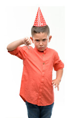 Canvas Print - Dark haired little child wearing birthday cap with angry face, negative sign showing dislike with thumbs down, rejection concept