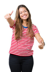 Canvas Print - Young beautiful brunette woman wearing stripes t-shirt over isolated background approving doing positive gesture with hand, thumbs up smiling and happy for success. Looking at the camera.