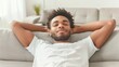 © ArtStockVault - Relaxed Young Man Enjoying Leisure Time on Modern Gray Sofa, Indoor Home Living Space, Casual Comfortable Setting in Bright Natural Light