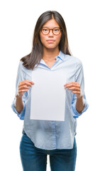 Poster - Young asian woman over isolated background holding blank paper with a confident expression on smart face thinking serious