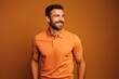 © Markus Schröder - Portrait of a blissful man in his 30s donning a classy polo shirt on pastel orange background
