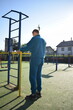 © AlDa.videophoto - A young man in athletic wear performs morning workout routine at an outdoor gym. He trains diligently on various fitness equipment, building strength endurance, to prepare his body at the sport area