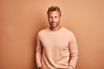 Poster - Portrait of a blissful man in his 30s dressed in a comfy fleece pullover over pastel brown background