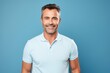 © Markus Schröder - Portrait of a satisfied man in his 40s wearing a sporty polo shirt in soft blue background