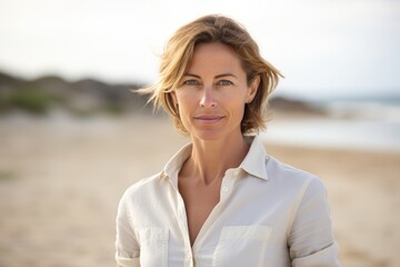 Poster - Portrait of a tender woman in her 40s donning a classy polo shirt while standing against sandy beach background