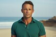 © Markus Schröder - Portrait of a tender man in his 40s donning a classy polo shirt in sandy beach background