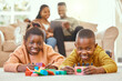 © peopleimages.com - Portrait, children and building blocks on floor in living room for development, learning or educational toys. Black family, kids with parents for activity, playing game or bonding together in home
