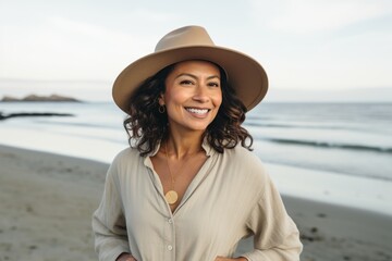 Sticker - Portrait of a joyful indian woman in her 40s donning a classic fedora in front of serene seaside background